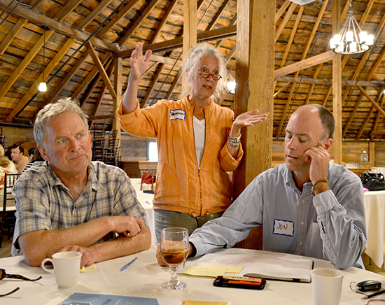 Workshop participants Jim Edgcomb(l) and Jon Jamieson (r) listen as consultant Patricia Floyd at the Economic Vitality Workshop at the Round Barn on August 13. Photo: Rachel Goff