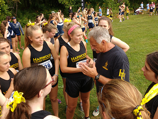 Harwood Cross Country coach John Kerrigan gives a pep talk before the girls meet. Photo courtesy John Kerrigan