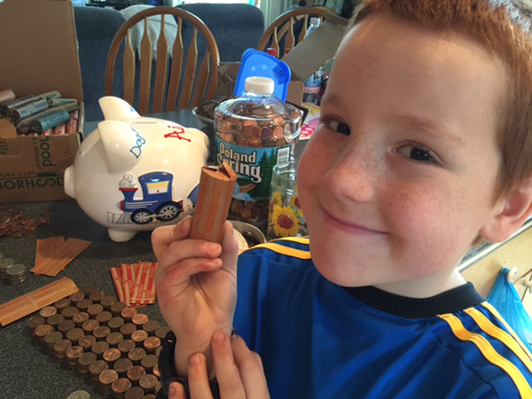 Aiden Heath rolls coins he has been saving since he was 4 years old after being diagnosed with type 1 diabetes at age 3. He plans to use the savings for a deposit on a service dog.