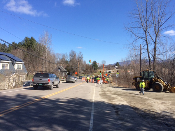 Drivers watch while VTrans employees close off the northbound lane of Route 100 through Duxbury for a temporary bridge due to a culvert failure.