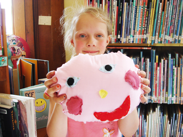 Lola holds her sewn stuffed head.