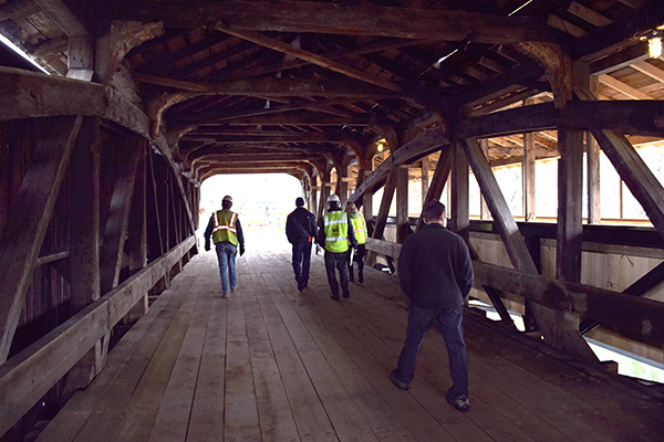 Waitsfield town employees and construction crews inspect the gap during the final walk through of bridge construction. Photo: Jeff Knight