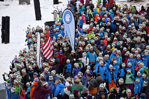 Mad River Glen and GMVS/Sugarbush junior racers who are part of VARA(Vermont Alpine Racing Association) were part of the World Cup opening ceremonies. MRG coach Chris Downing waves an American Flag. Photo: Jeff Knight