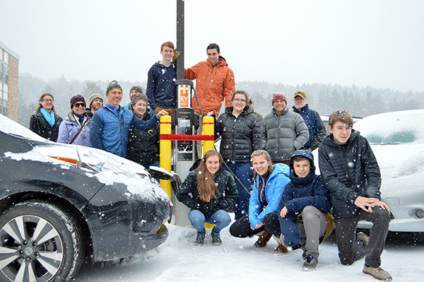 Harwood students and members of the school board and Washington Electric Co-op gather in the parking lot for the ceremonial opening of Harwood’s new EV charging station. Photo: Chris Keating