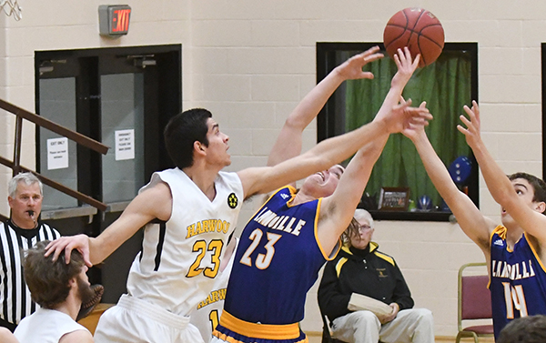 Harwood Union senior Shiv Seethepalli (No. 23) gets a helping head from teammate senior Evan Pearl (No. 14) during the Harwood 51-45 win over Lamoille on Saturday, February 11. Photo: John Williams