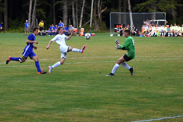 Harwood's Will Lapointe takes on the Lamoille goal keeper. Photo: Christopher Keating