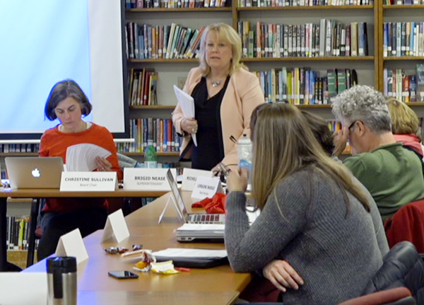 Harwood Unified Union School District (HUUSD) Superintendent Brigid Nease hands out white paper on district redesign to the unified school board. Video capture from MRVTV