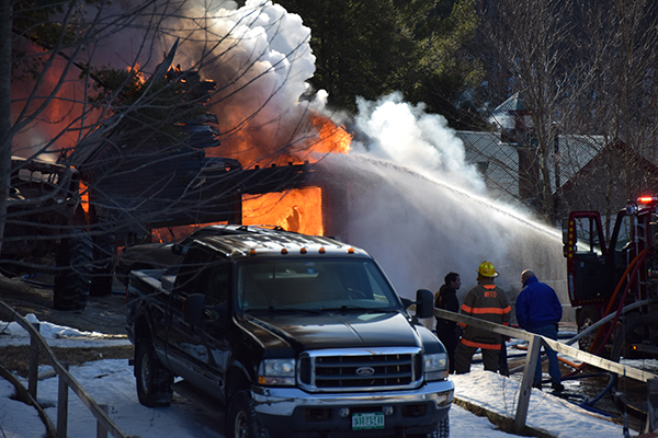 Flames billow from Tiger's Auto Repair as firefighters fight the blaze. Photo: Jeff Knight