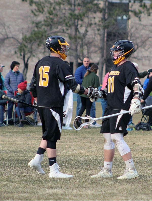 Harwood lacrosse team members Jake Wells and Oli Hammond congratulate each other.