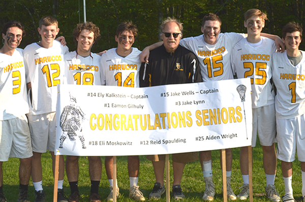 Harwood lacrosse seniors  pose for a photo with head coach Russ Beilke following their defeat of Lamoille on senior night.