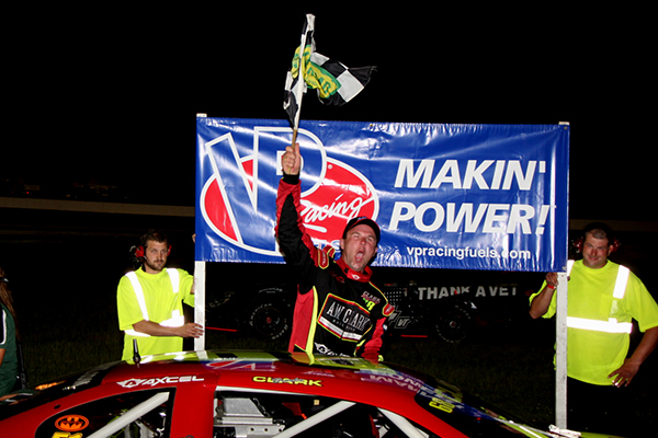 Brooks Clark, waves the checkered flag after winning the Governor’s Cup race at Thunder Road on July 18.