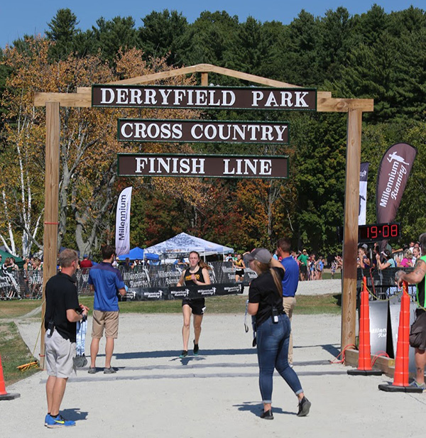 Ava Thurston crossing the finish line to take first place at the New England Small School Championship.