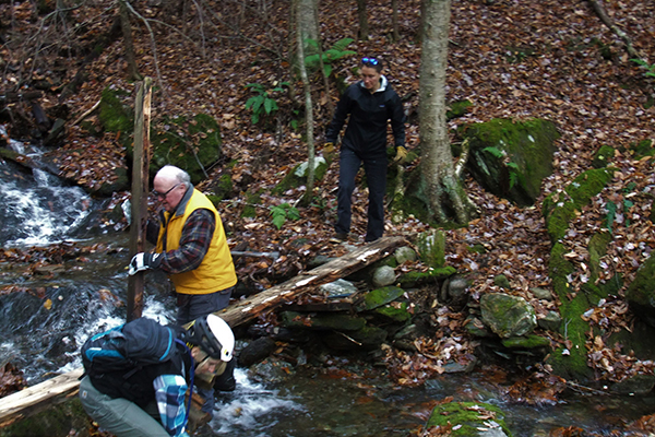 Duxbury Land Trust members remove a dilapidated foot bridge in the Duxbury Town Forest.
