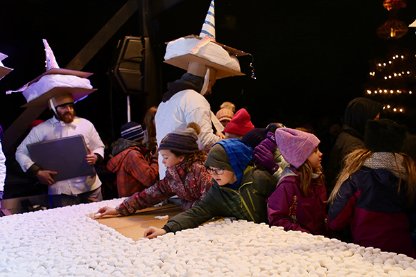 Children carefully place the marshmallows for the world’s largest s’more. This year’s Winter S’morestice Celebration takes place on December 28 at Camp Meade in Middlesex.