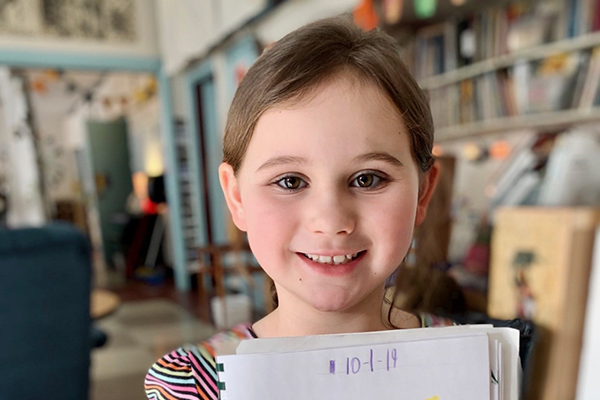 Photo: Hadley Laskowski. Julia Hill proudly displays her close-up drawing of a leaf. “I love the outdoors and animals,” Julia  said. “I love ’em. They’re just really important. Cuz if we didn’t have animals, what would happen?”