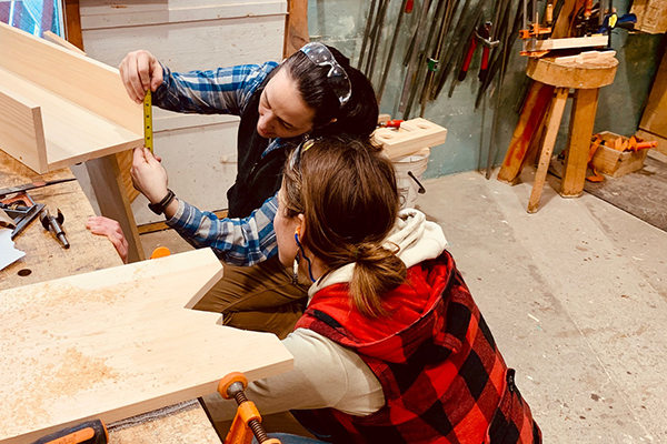 Instructor Lindley Brainard checks a measurement with one of her students in the Powertools for Women course recently held at Yestermorrow. Photo: Hadley Laskowski. 