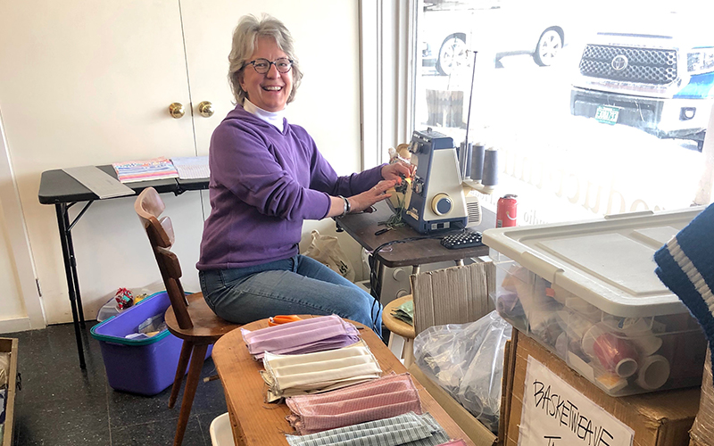 Kris Chamberlain of Warren sits  at the serge machine which is used to pleat the medical masks. Photo courtesy of Product Think Tank.