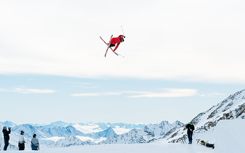A freestyle skier doing acrobatics in the air.