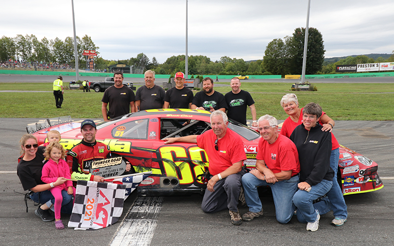 Brooks Clark celebrates his Thunder Road Labor Day Classic win with family and pit crew. Pictured, from bottom far left: Brooks’ wife, Lacey and children Beckett and Alexis; Brooks; dad, Tom Clark; uncle, Dave Clark; mother, Leigh; sister, Hilary. Pit crew from left: Ryan Foster, Steve Guptil, Marc Bard, Eric Austin, Jason Woodard. Photo: Buzz Fisher, CreativeOutbursts.com