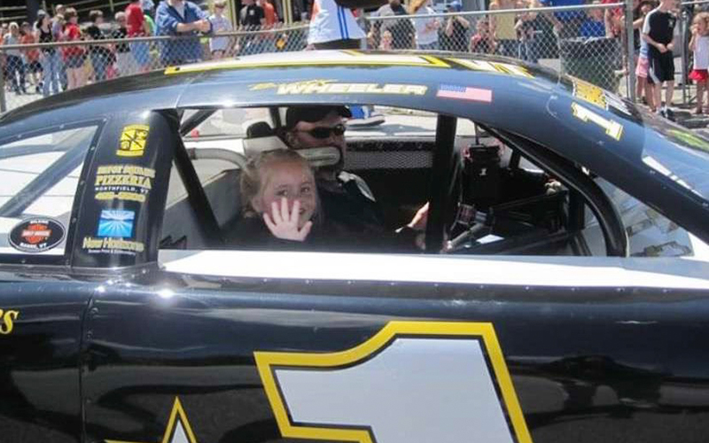 A young Shea Wheeler rides with her father at Thunder Road.