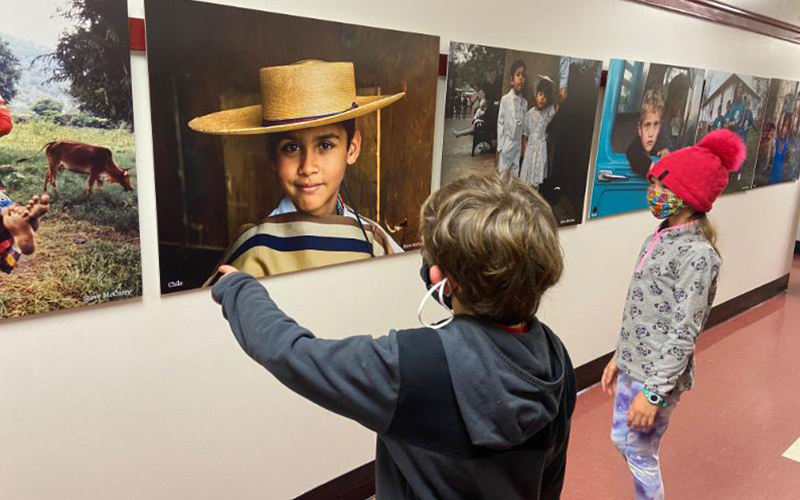 Students at Moretown Elementary School look at "The Faces of Innocence" photo exhibit donated by the Besharat Arts Foundation.