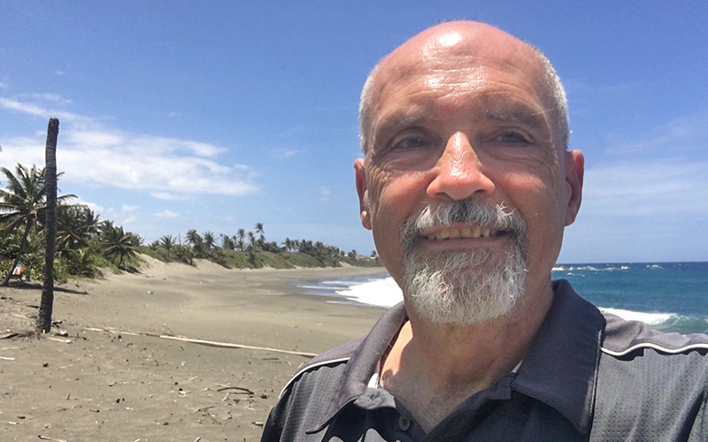 Photo of Howie McCausland on a beach.