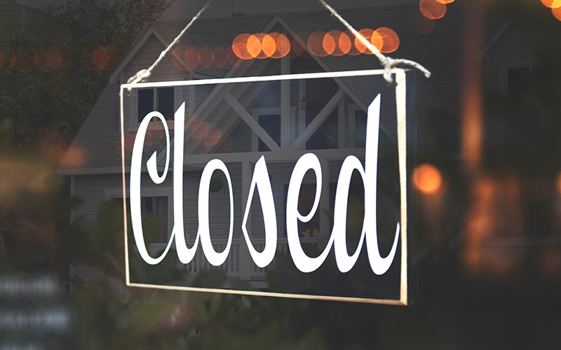 A closed sign hanging in a business window