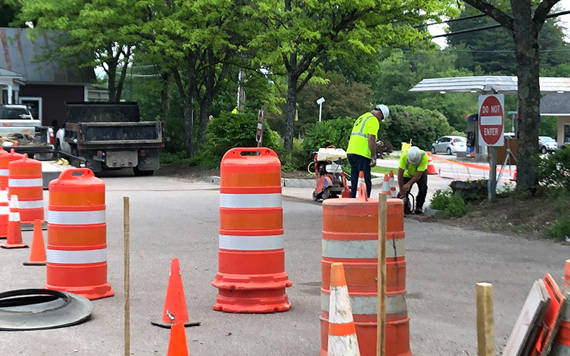 Construction workers slicing pavement as part of the expanded curb cut for the Irasville Country Store in Waitsfield, VT