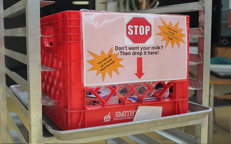 milk carton with sign reading "Don't want your milk? Then drop it here! the milk will go to local food shelves"