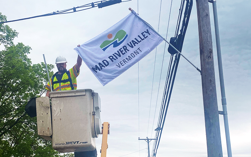 Waitsfield Telecom workers putting up new Chamber of Commerce flags.