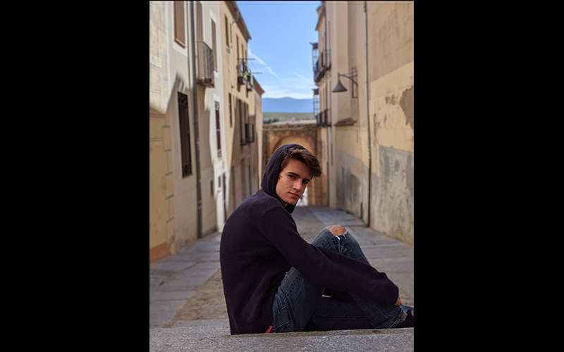 The Valley Reporter intern Ben Nardin sitting in an old world street.