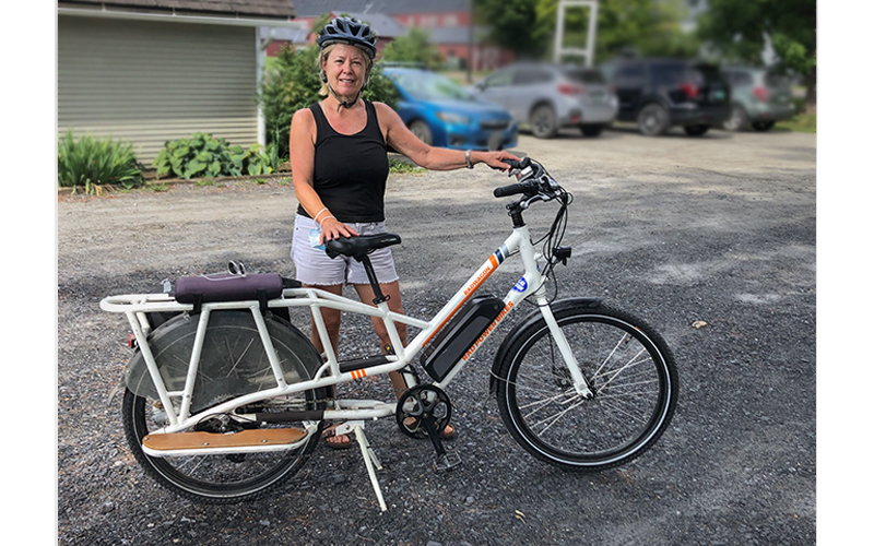 June Anderson stands next to one of the e-bikes the Mad River Valley Recreation District and Local Motion made available in The Valley to try. Photo: LIsa Loomis