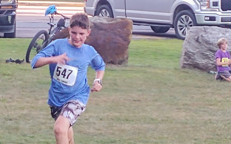 Sanders Kasvinsky running around the field while a friend watches