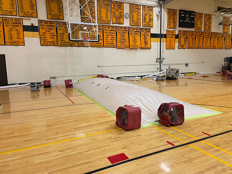 A section of the Harwood gym that was most damaged by water is tented to increase drying