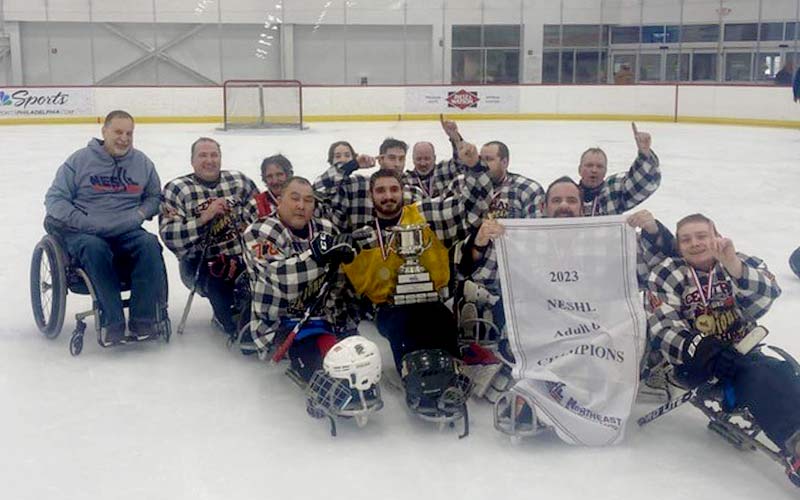 Pioneer sled-hockey team poses with their trophy.
