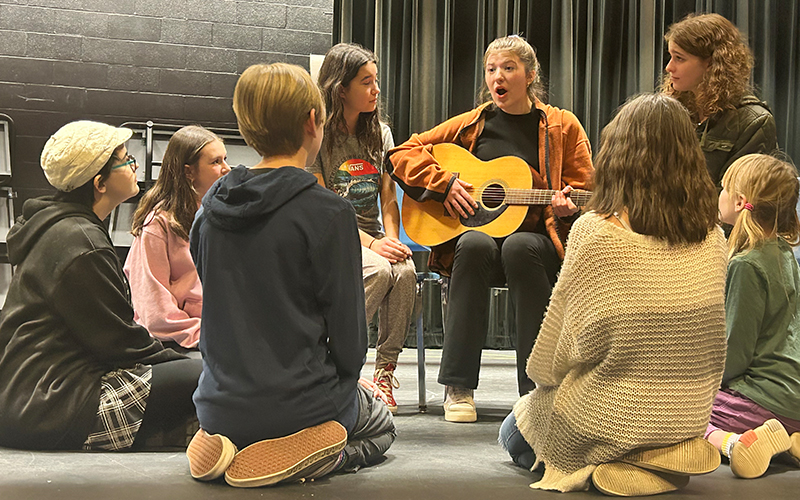 Harwood Union Middle and High School will present “The Sound of Music” April 6-8. Pictured above during a rehearsal: Maria, played by Harwood senior Abby Holter, sings to the von Trapp children. The von Trapp children are: Liesl, played by Zoe Blackman; Freidrich, played by Tarin Askew; Louisa, played by Emma Riley; Kurt, played by Robin Weigand; Brigitta, played by Harmony Devoe; Marta, played by Ari Weigand; and Gretl, played by Desi Dahlgren.