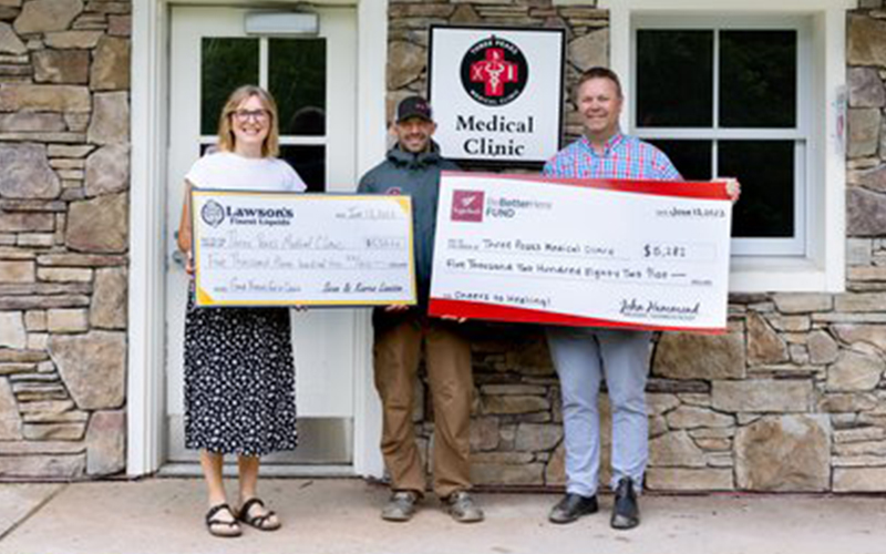 Chad Borofsky, center, president of the Three Peaks Medical Clinic board receives donation checks from Karen Lawson, left, of Lawson’s Finest Taproom and John Hammond, right, of Sugarbush Resort. Photo: Corinne Chiarchiaro.