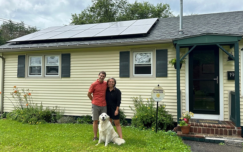 Ian Shea with partner Logan Shuman and their dog Maverick at their home with rooftop solar in downtown Waterbury. Photo by Lisa Scagliotti.
