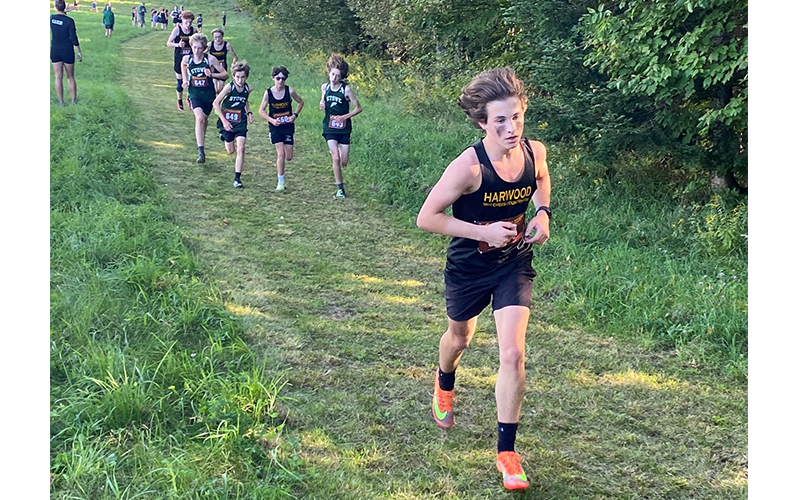 HU boys tackling the steep muddy hill at Danville meet. Chapin Rivers leading the pack, followed by Brody Hackett (in sunglasses, sandwiched by Stowe runners), Cooper Hansel and Atticus Ellis close on their heels. Photo: Robert Cummiskey