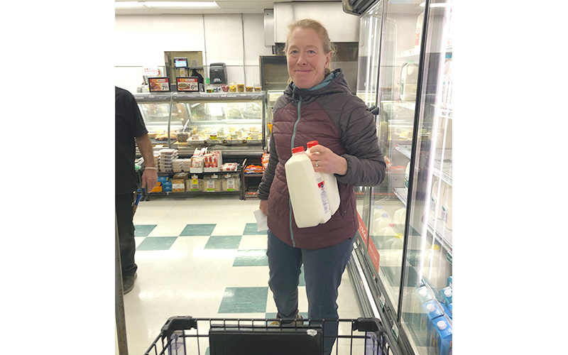 Mad River Valley Community Pantry volunteer shopper Krista Glow selects milk from the dairy case at Shaw’s while restocking the community pantry this week