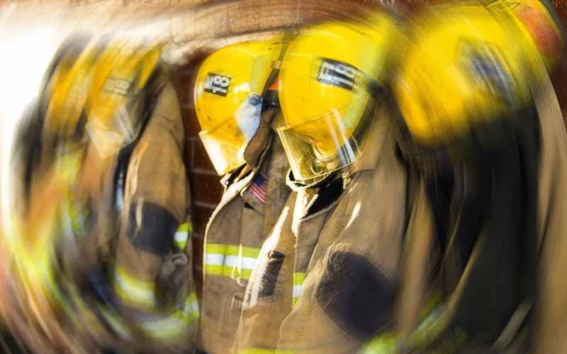 firefighter gear hanging on a wall