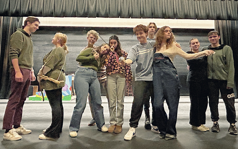 Center stage, Aiden Heath as Gomez and Zoe Blackman as Morticia, are surrounded by their fellow cast members of “The Addams Family.” The musical will be presented April 4 through 6 in the Harwood auditorium.