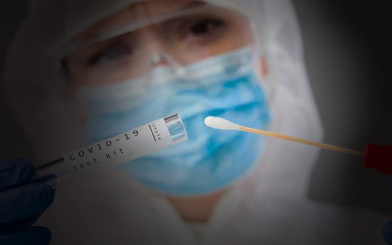 medical person with a test tube and COVID testing swab.