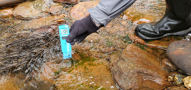 Measuring temperature and conductivity in the Mad River. Photo courtesy of Friends of the Mad River.